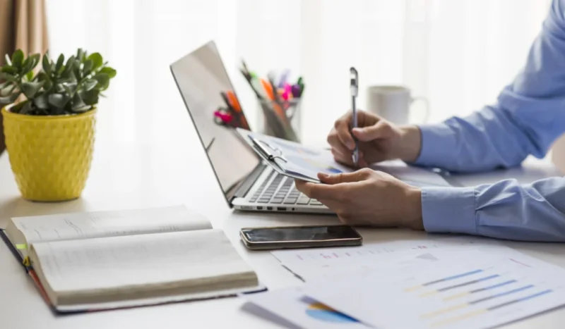 crop-man-writing-documents-office